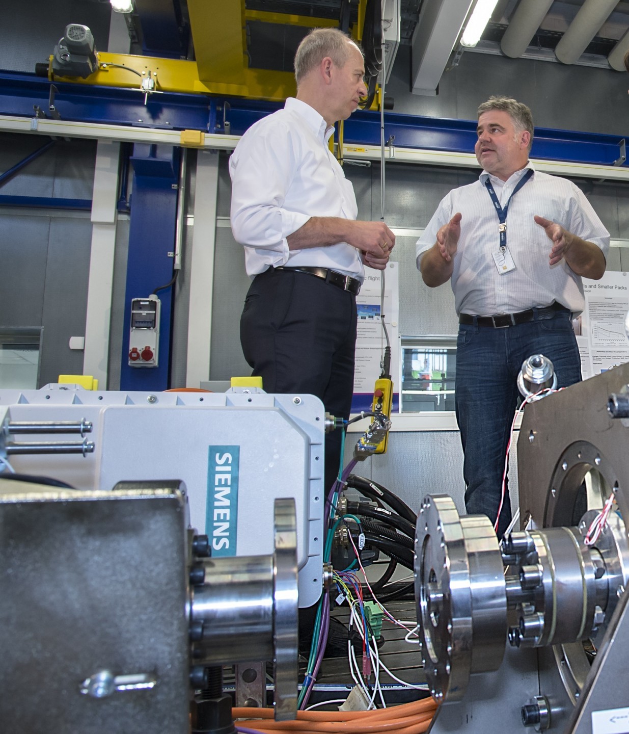 Martin Nüsseler (uprostřed) a Joachim Zoll (vlevo) nad testovaným leteckým elektrickým motorem o výkonu 260 kW.